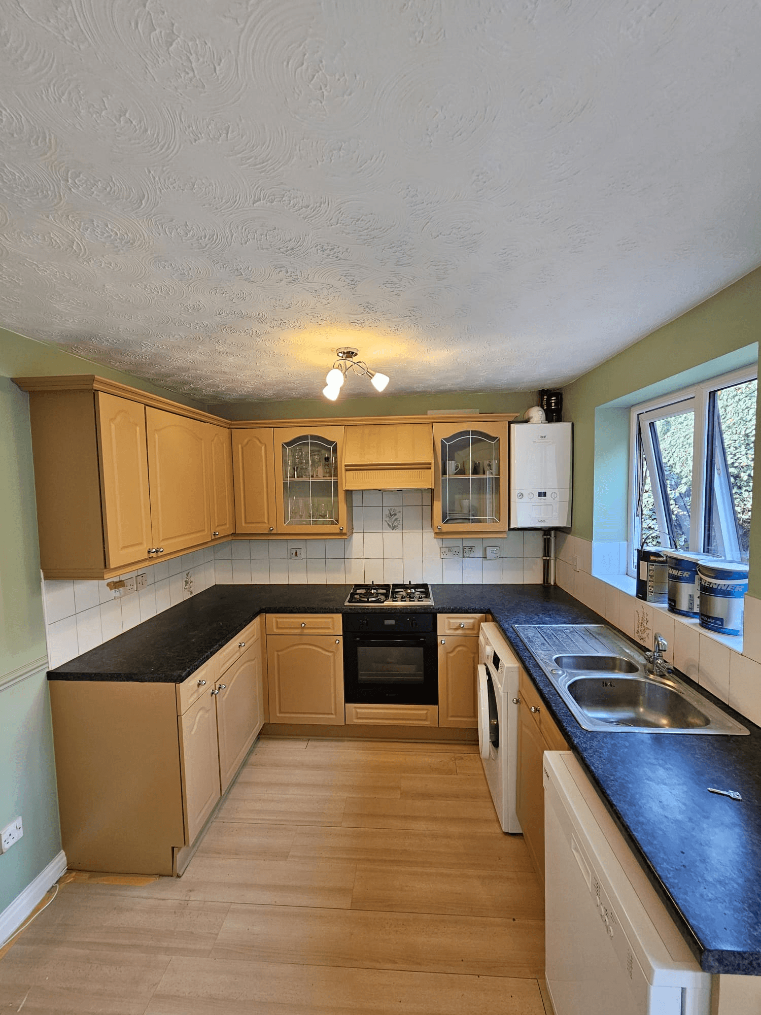 Kitchen respray Sheffield — completed beige kitchen with black worktops and sage green walls