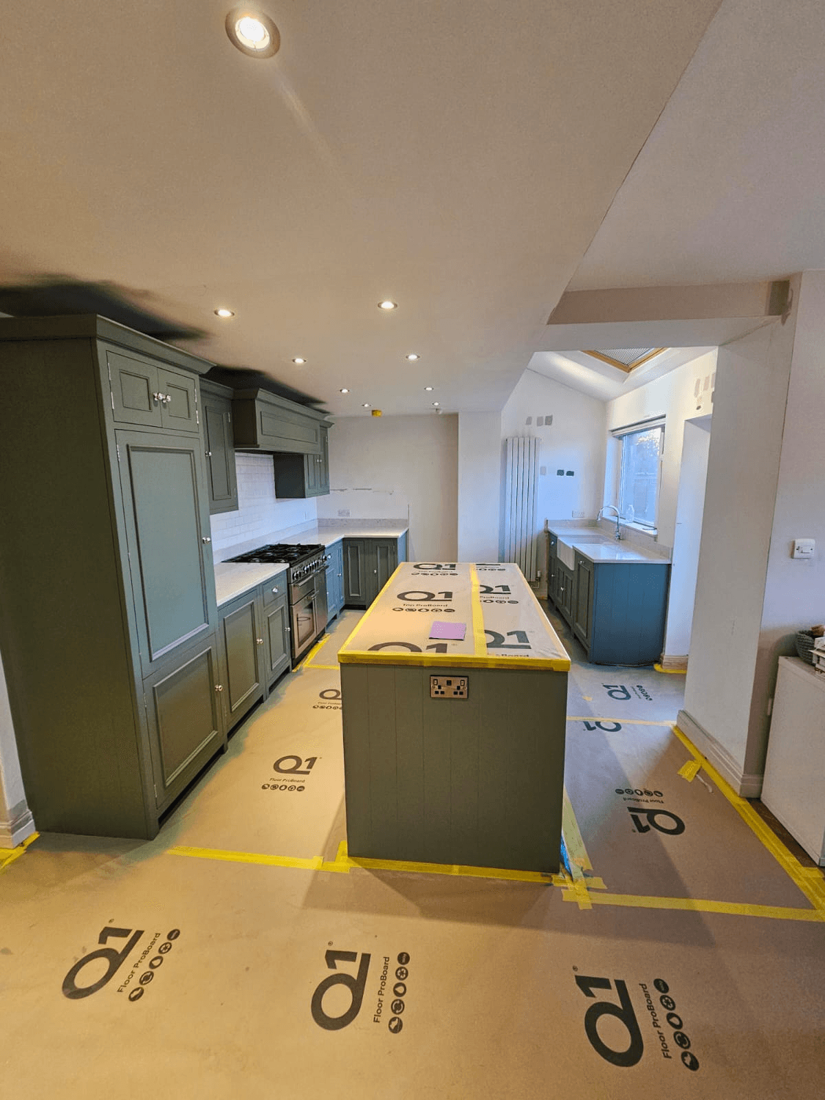 Kitchen spraying Sheffield — dark green colour change in progress with floor protection